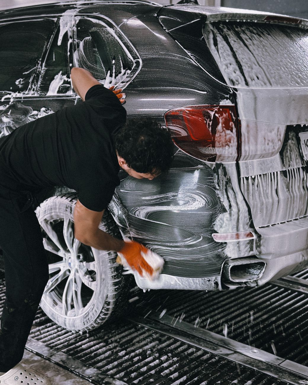 person washing car with soap and sponge